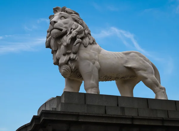 White lion statue with blue sky in London