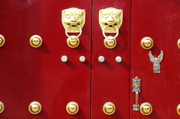 Red door decorated with golden door knobs