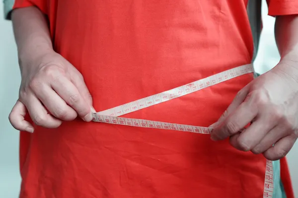 Fat woman measuring waist