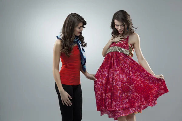 Happy two women trying red flower dress