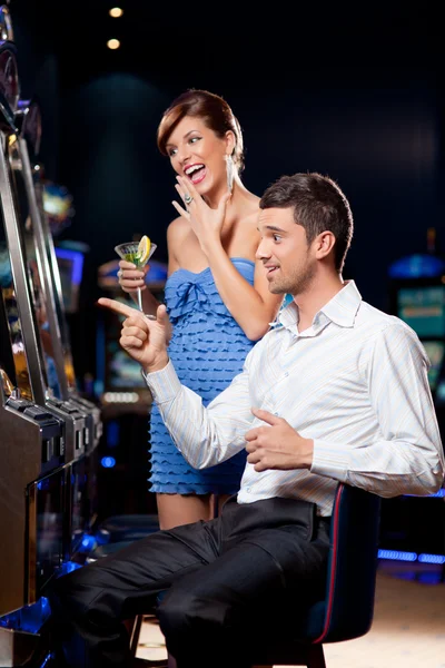 Young couple winning at the slot machine