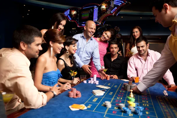 Happy friends playing roulette in a casino