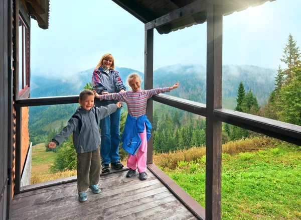 Family on wooden mountain cottage porch