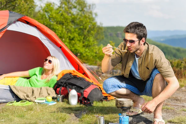 Camping young couple with tent cook countryside