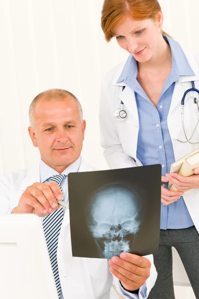 Medical team doctors look at head x-ray