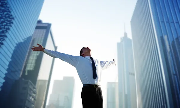 Happy young businessman and big city