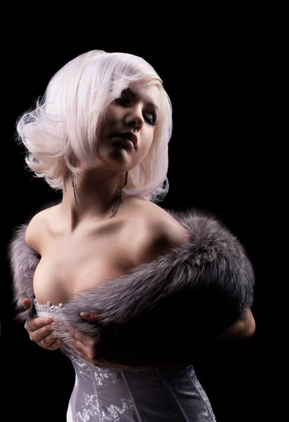 Beauty blonde posing in corset and fur boa