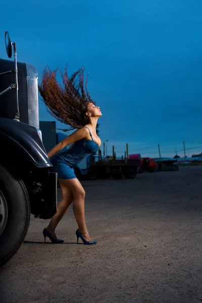 Young beauty girl posing near steel truck