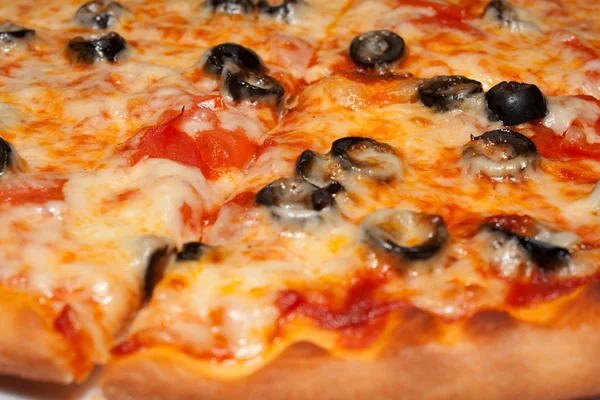 Pizza with black olives and melted cheese, close-up shooting