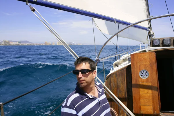 Sailor sailing blue tropical sea on sailboat