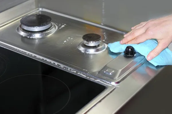 Woman hand cleaning kitchen cooking top