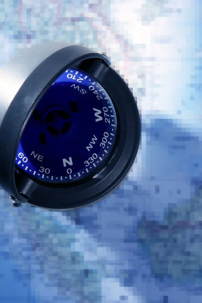 Blue nautical compass over blue chart map