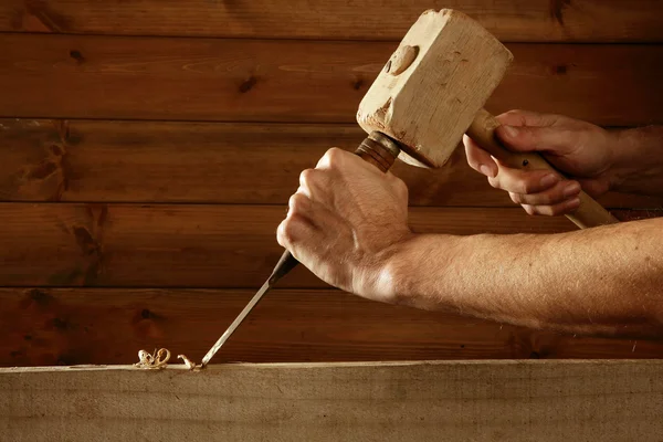 Gouge wood chisel carpenter tool hammer in hand working wooden 