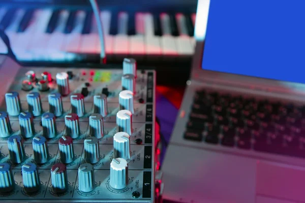 Audio mixer music desk under colorful lights