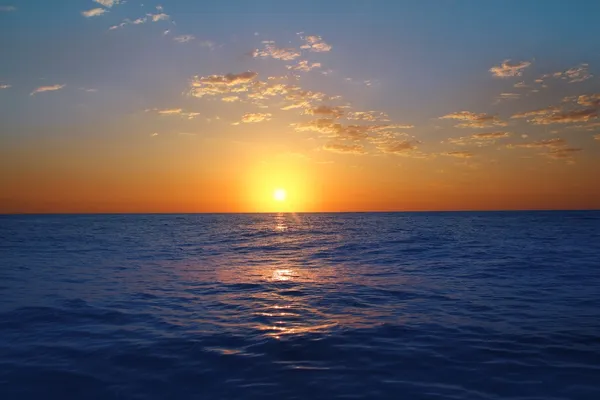 Sunrise sunset in ocean blue sea glowing sun