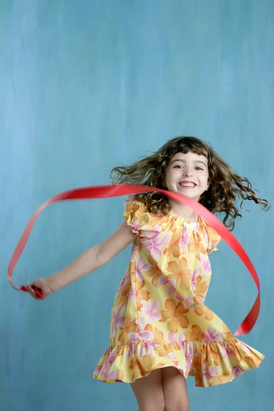 Little girl red ribbon tape dancing over green