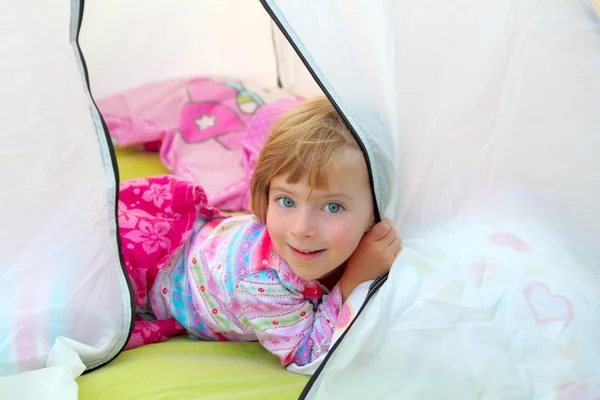 Girl in camping tent lying on camp tent