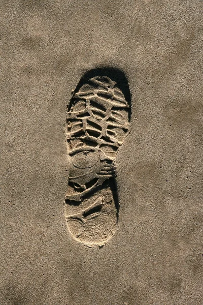 beach sand footprints. shoe on each brown sand