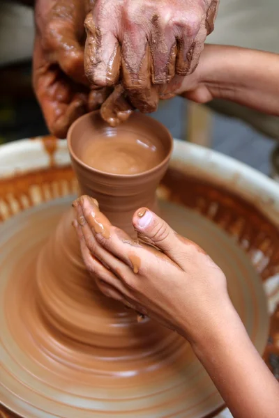 Craftsman potter hands of teacher and pupil clay pottery