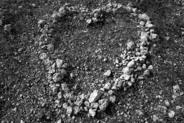 Black and white heart shape stones on soil
