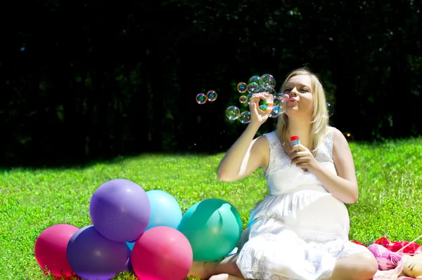 Pregnant woman blowing bubbles