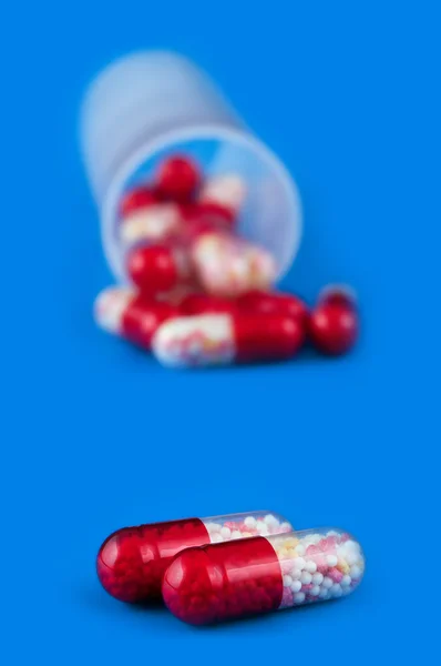 Red pills isolated on blue background