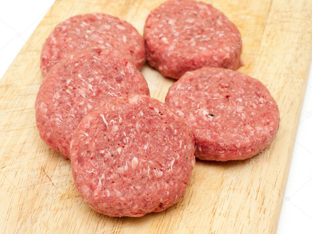 SEARCH AND BUY THIS PRODUCT Raw beef burgers close up on a board — Stock Photo © Anvar