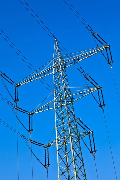 Electricity tower with power lines against a blue sky