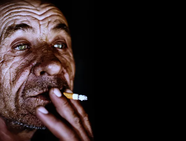 Old wrinkled man smoking