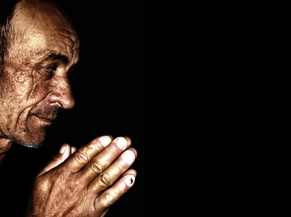 Old wrinkled man praying