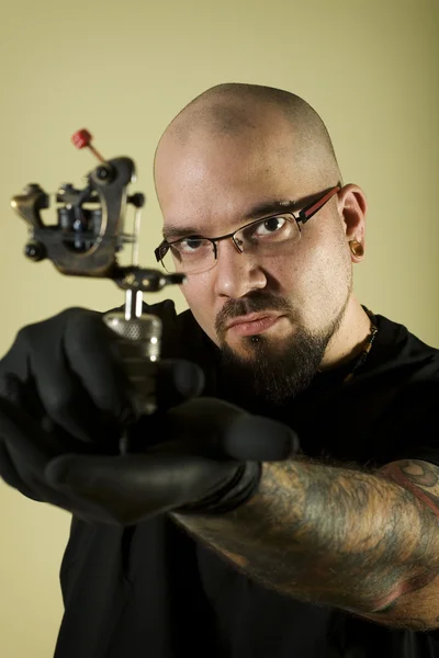 Tattoo artist holding his machine