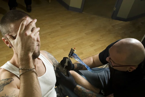 Client in pain getting a tattoo