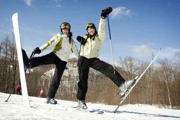 Two sisters on mountain top excited to be skiing