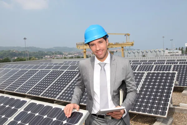Businessman standing on solar panel installation