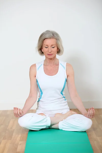 Senior woman doing yoga exercises