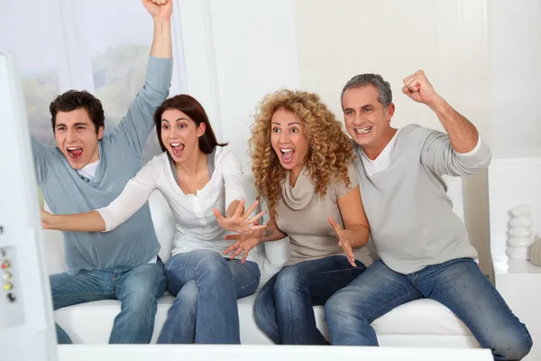 Group of friends sitting in sofa watching tv