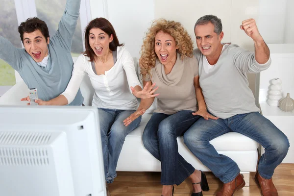 Group of friends sitting in sofa watching tv