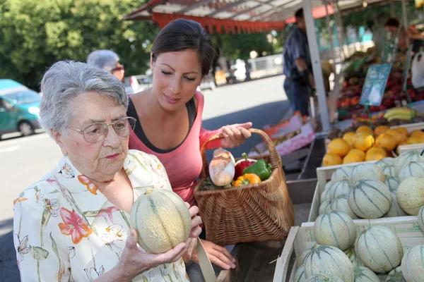 Young woman with elderly woman in grocery shopping