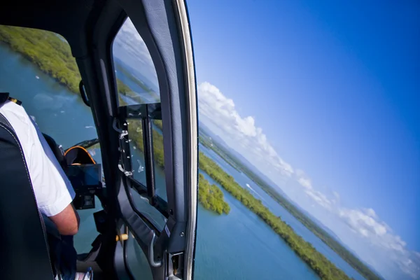 Inside helicopter in air without door looking at scenery