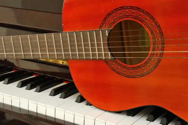Acoustic guitar on piano keyboard