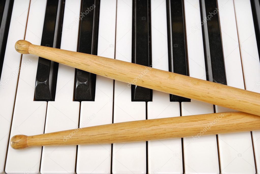 Drum sticks on piano keyboard — Stock Photo © gnohz 5840619