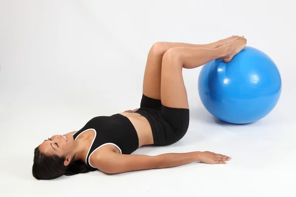 Woman with feet on exercise ball