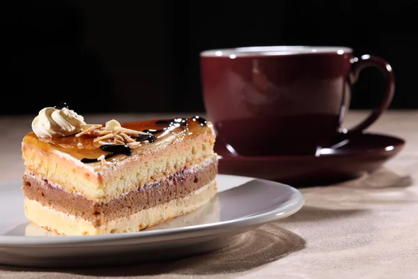 Cup coffee and cake with chocolate sauce topping