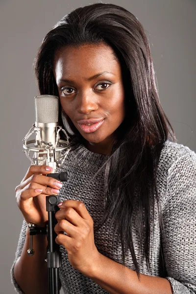 Portrait happy black woman singer in music studio