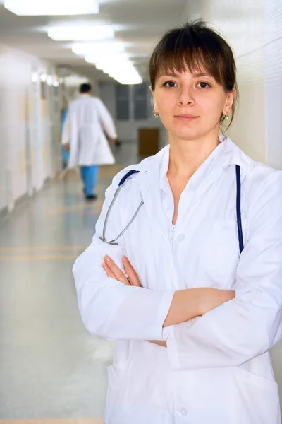 Female doctor in corridor under lamps