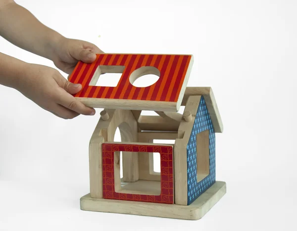 Boy hands and wood colorful house toy