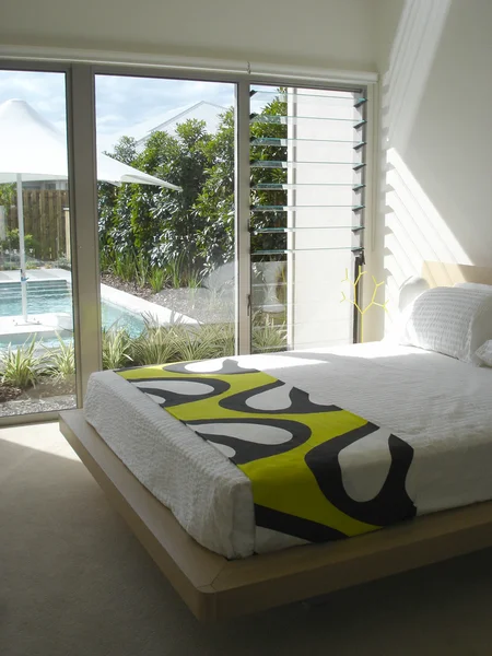 Sunny master bedroom with pool view