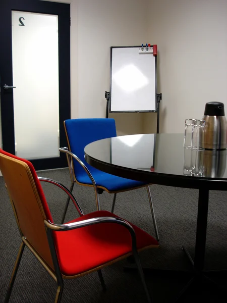 Business meeting room with bright red and blue modern chairs