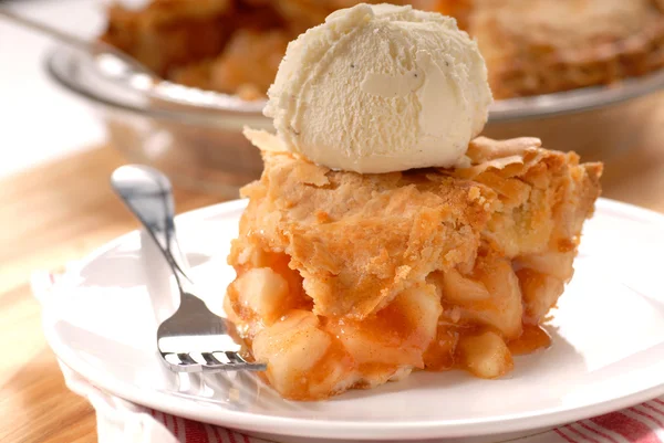Slice of deep dish apple pie with vanilla ice cream