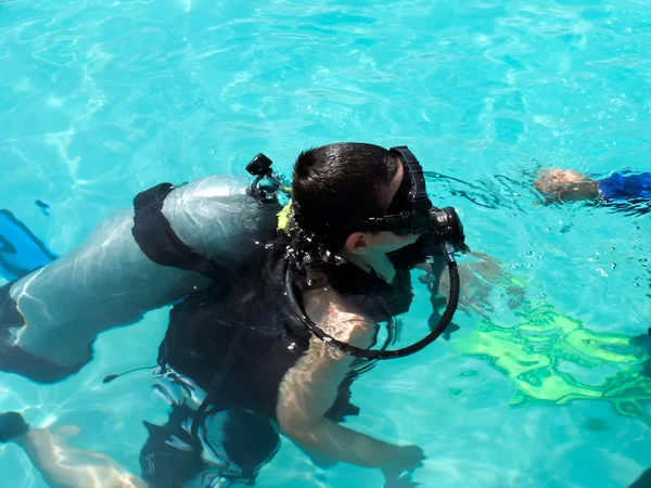 A boy taking scuba diving lessons in the caribbean resort.